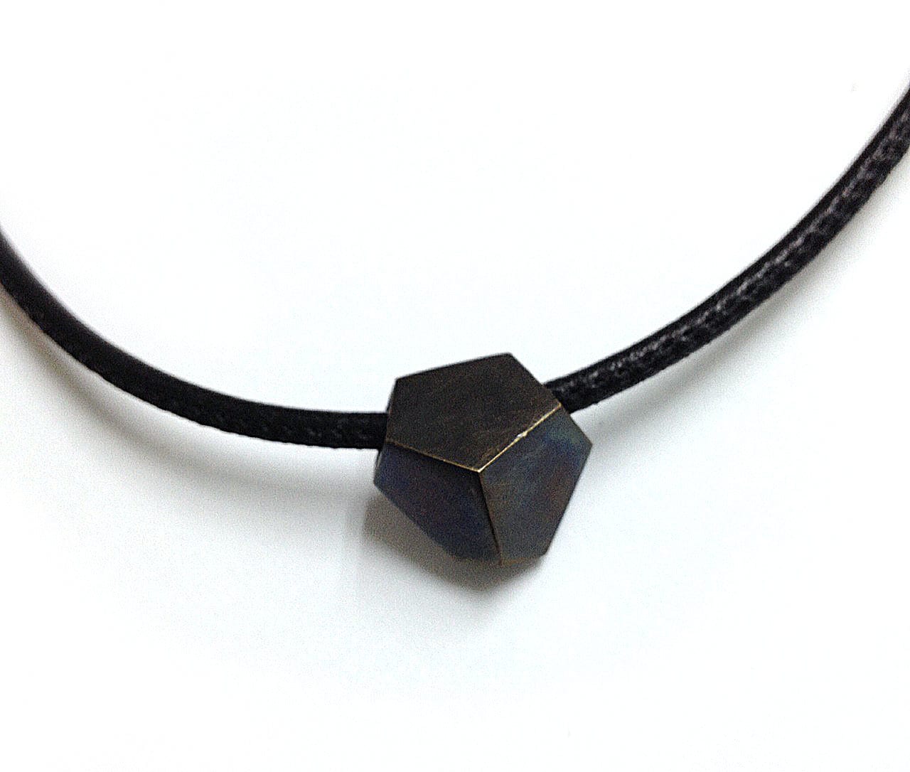Geometric hexagon shaped oxidized bronze charm on stitched leather chord.  Choker necklace